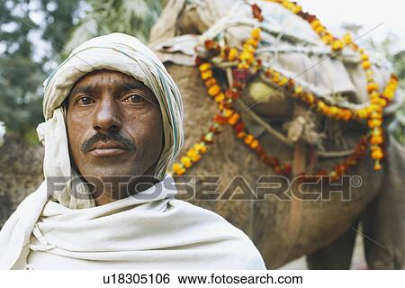 Portrait of a mid adult man standing with a camel View Large Photo Image Stock Photograph - Portrait of a mid adult man standing with a camel. Fotosearch