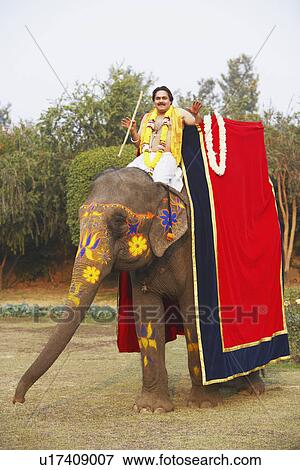 Stock Photo - Portrait of a priest riding an elephant. Fotosearch