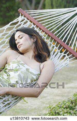 High angle view of a young woman sleeping in a hammock View Large Photo Image Stock Image - High angle view of a young woman sleeping in a hammock. Fotosearch