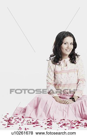 Stock Photo - Portrait of a young woman sitting and smiling. Fotosearch