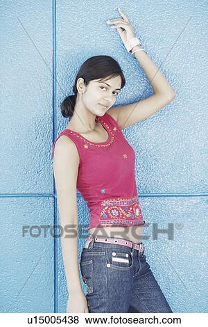 Stock Photo - Portrait of a young woman standing with her hand raised. Fotosearch