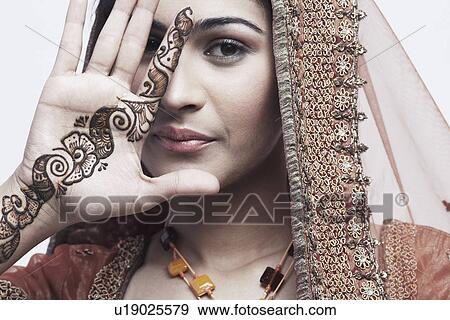 Stock Photo - Portrait of a young woman with henna tattoo's on her hand. Fotosearch