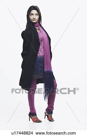 Picture - Young woman standing with her hands in her pockets. Fotosearch