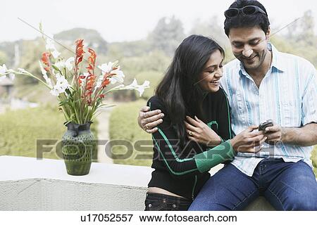 Stock Photo - Close-up of a young couple looking at a mobile phone. Fotosearch