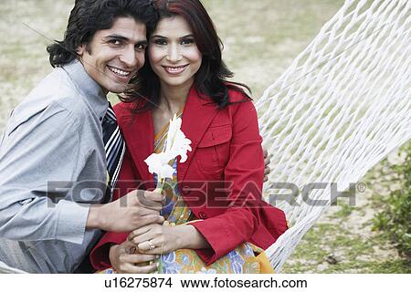 Close-up of a young couple sitting in a hammock View Large Photo Image Picture - Close-up of a young couple sitting in a hammock. Fotosearch