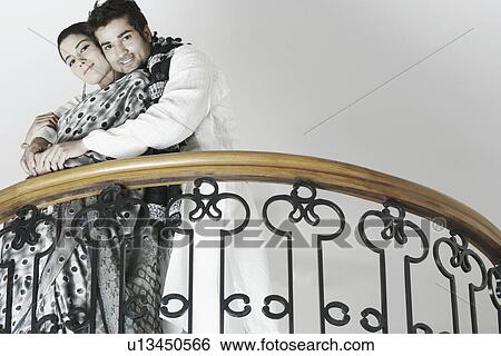 Low angle view of a young man embracing a young woman View Large Photo Image Stock Photograph - Low angle view of a young man embracing a young woman. Fotosearch