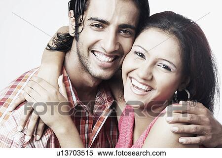 Stock Photography - Portrait of a young couple embracing each other smiling. Fotosearch