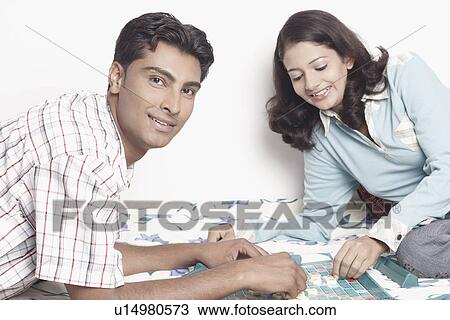 Side profile of a young couple playing scrabble View Large Photo Image Stock Image - Side profile of a young couple playing scrabble. Fotosearch