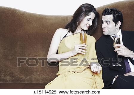 Stock Photography - Young couple holding champagne flutes. Fotosearch