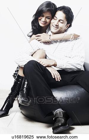 Young couple sitting on a bean bag View Large Photo Image Stock Photography - Young couple sitting on a bean bag. Fotosearch
