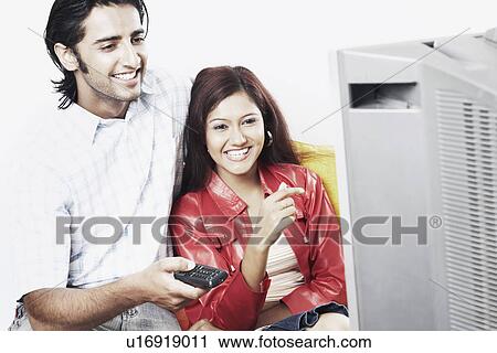 Young couple watching television View Large Photo Image Stock Image - Young couple watching television. Fotosearch