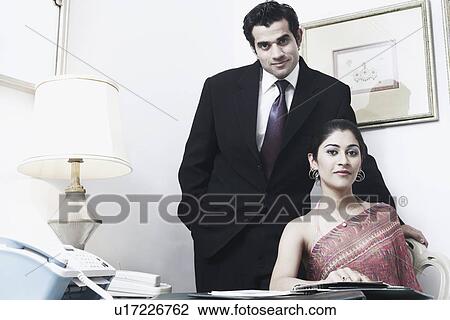 Stock Image - Portrait of a businessman and a businesswoman in an office. Fotosearch