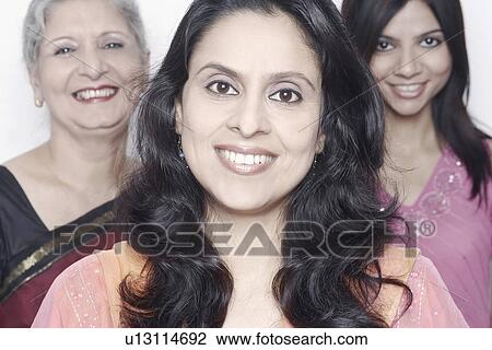 Portrait of a mid adult woman smiling with two women standing behind her View Large Photo Image Stock Image - Portrait of a mid adult woman smiling with two women standing behind her. Fotosearch