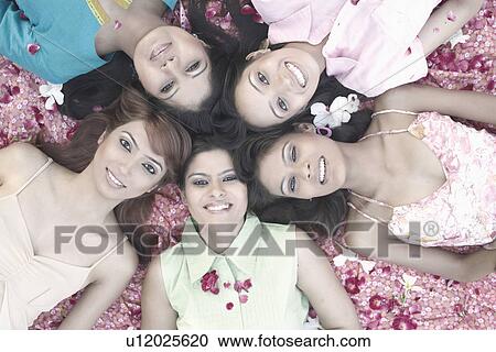 Stock Image - Portrait of a teenage girl and four young women lying on their back. Fotosearch