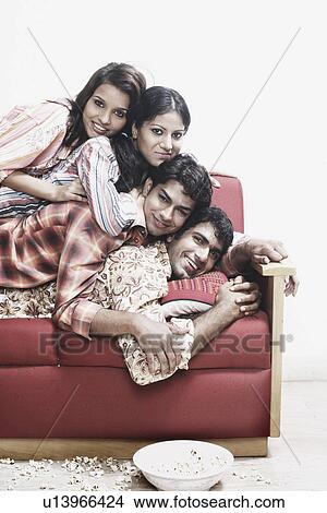 Portrait of two young men and two young women lying on top of each other smiling View Large Photo Image Picture - Portrait of two young men and two young women lying on top of each other smiling. Fotosearch