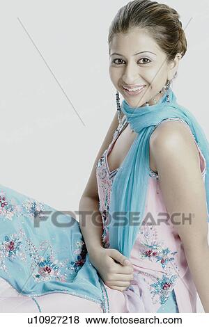 Stock Photo - Side profile of a young woman smiling. Fotosearch