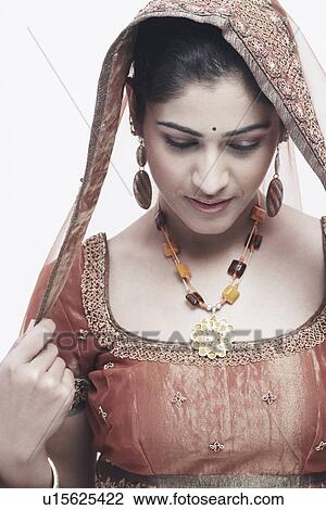 Stock Image - Close-up of a young woman in traditional clothing looking down. Fotosearch