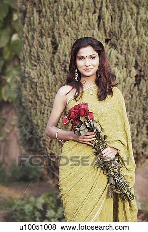 Portrait of a young woman holding a bunch of roses View Large Photo Image Stock Photo - Portrait of a young woman holding a bunch of roses. Fotosearch