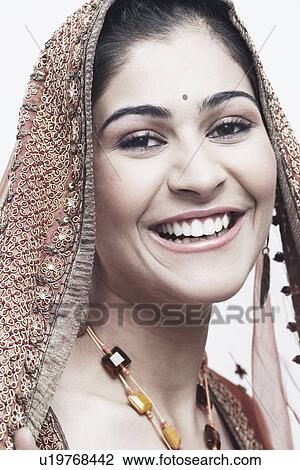 Stock Image - Portrait of a young woman in traditional clothing smiling. Fotosearch