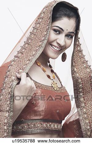 Stock Photo - Portrait of a young woman in traditional clothing smiling. Fotosearch