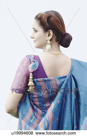 Rear view of a young woman wearing a sari View Large Photo Image Stock Photo - Rear view of a young woman wearing a sari. Fotosearch