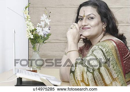 Stock Photography - Side profile of a mature woman sitting in front of a laptop. Fotosearch