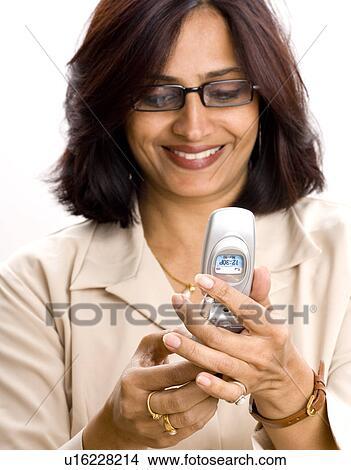 Close-up of a mid adult woman using a mobile phone View Large Photo Image Picture - Close-up of a mid adult woman using a mobile phone. Fotosearch