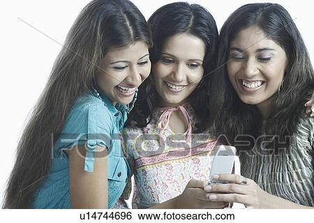Stock Photograph - Close-up of a young woman looking at a mobile phone. Fotosearch