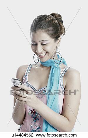 Stock Image - Close-up of a young woman operating a mobile phone. Fotosearch