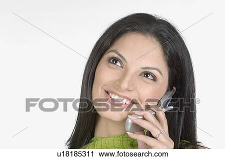Stock Image - Close-up of a young woman talking on a mobile phone. Fotosearch