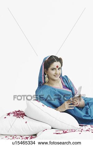 Portrait of a young woman holding a mobile phone View Large Photo Image Picture - Portrait of a young woman holding a mobile phone. Fotosearch