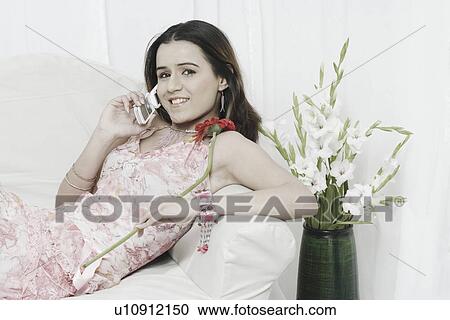 Portrait of a young woman talking on a mobile phone View Large Photo Image Stock Image - Portrait of a young woman talking on a mobile phone. Fotosearch