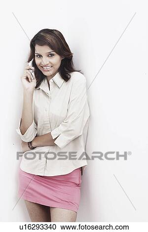 Stock Image - Portrait of a young woman talking on a mobile phone. Fotosearch