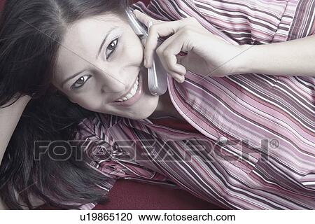 Stock Image - Portrait of a young woman talking on a mobile phone. Fotosearch
