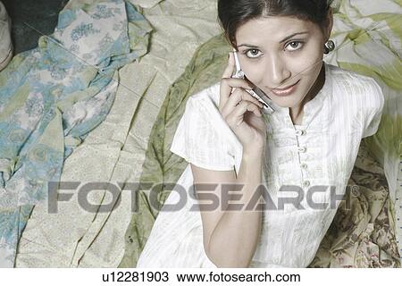 Stock Image - Portrait of a young woman using a mobile phone. Fotosearch