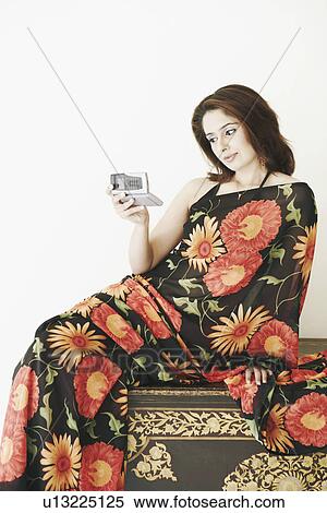 Stock Photography - Young woman looking at a mobile phone. Fotosearch