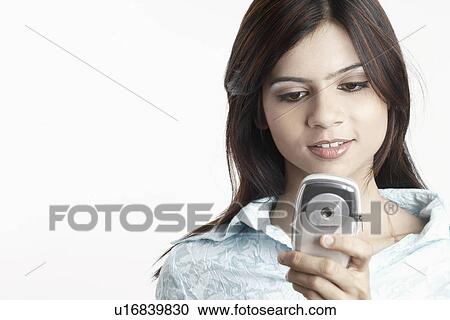 Stock Image - Young woman using a mobile phone. Fotosearch
