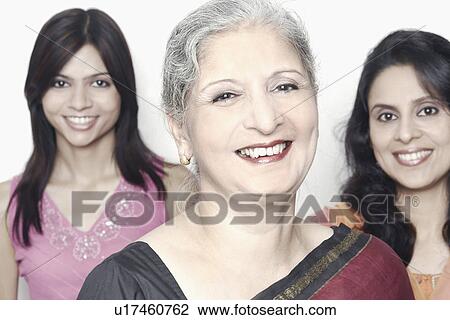 Portrait of a mature woman smiling with two women standing behind her View Large Photo Image Stock Image - Portrait of a mature woman smiling with two women standing behind her. Fotosearch