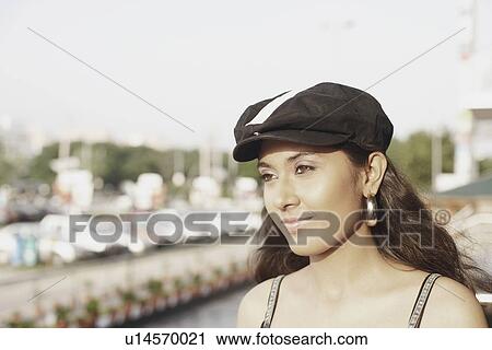 Stock Image - Close-up of a young woman wearing a cap. Fotosearch
