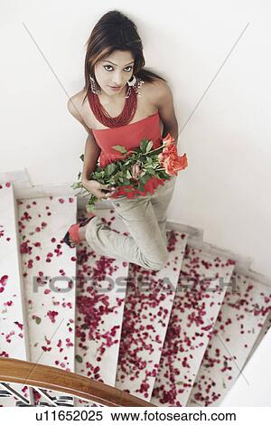 Stock Photography - High angle view of a young woman holding a bouquet of flowers. Fotosearch