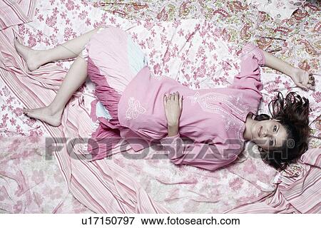Portrait of a young woman lying on her back View Large Photo Image Stock Photo - Portrait of a young woman lying on her back. Fotosearch