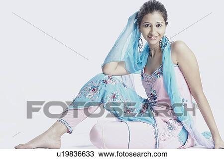 Side profile of a young woman with her hand on her head smiling View Large Photo Image Stock Image - Side profile of a young woman with her hand on her head smiling. Fotosearch