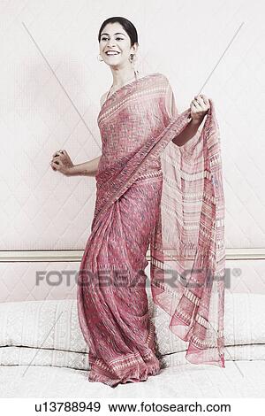 Stock Photo - Young woman dancing on the bed. Fotosearch