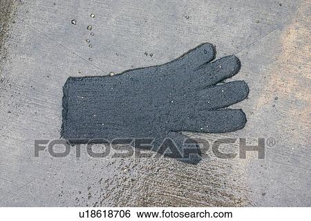 Stock Photograph - Lost glove on wet sidewalk. Fotosearch