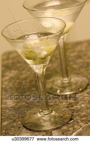 A couple of long stemmed glasses filled with martinis and waiting to be consumed View Large Photo Image Stock Photo - A couple of long stemmed glasses filled with martinis and waiting to be consumed. Fotosearch