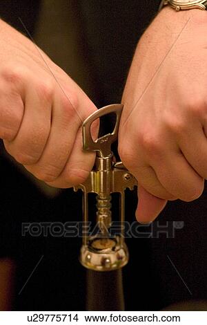 Picture - Opening a bottle of wine with a corkscrew. Fotosearch