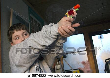 Boy aiming colorful toy cap gun View Large Photo Image Stock Image - Boy aiming colorful toy cap gun. Fotosearch