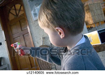 Stock Photography - Boy aiming colorful toy cap gun. Fotosearch