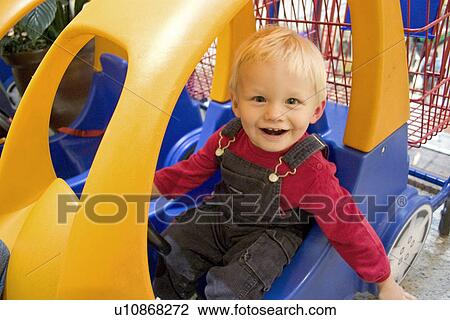 Toddler having fun in a shopping car View Large Photo Image Stock Image - Toddler having fun in a shopping car. Fotosearch