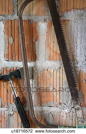 Stock Image - Hanging saw and axe in a Polish garage. Fotosearch